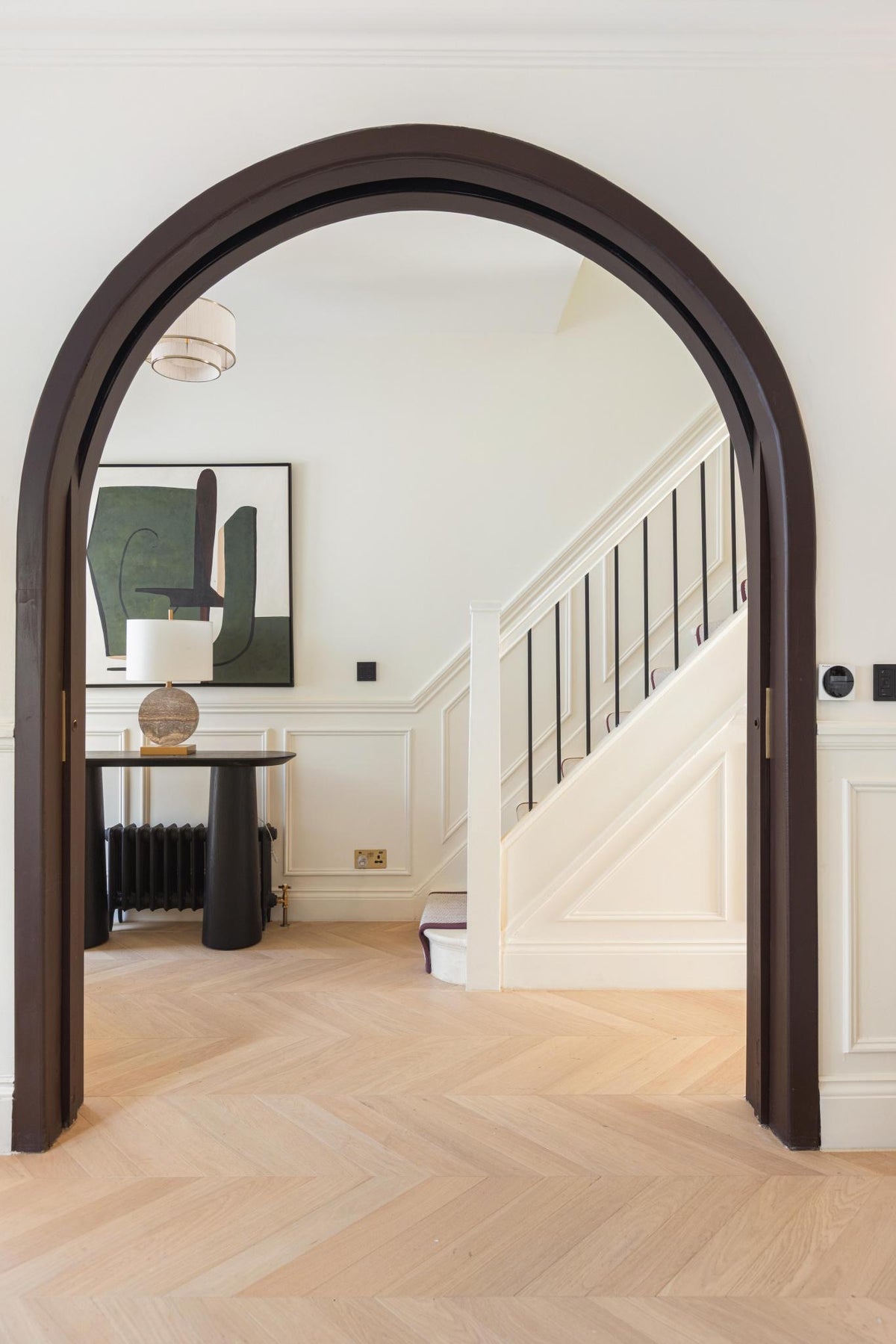 Arched oak doorway framing a hallway and staircase, West Hampstead home, London