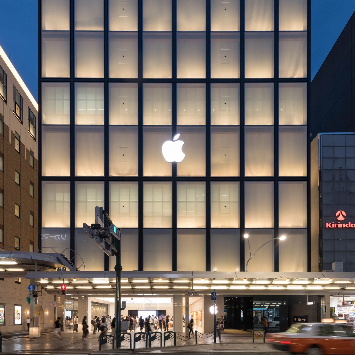 Apple Kyoto façade with backlit glazing at dusk