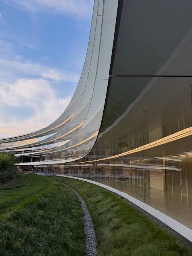 Ring building façade curving above a landscaped meadow, Apple Park, Cupertino, California